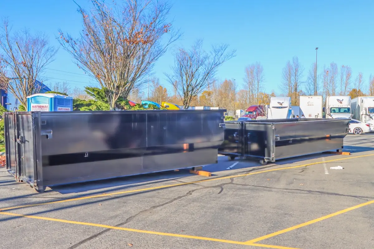 Professional dumpster rental service with roll-off container on residential driveway in Parsons